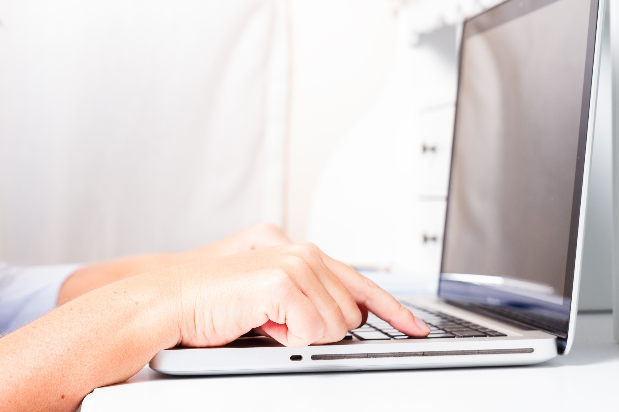 hands on laptop keyboard