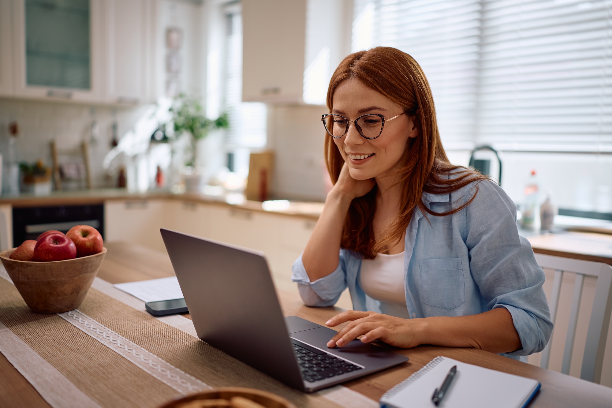 Happy woman working on laptop at home.