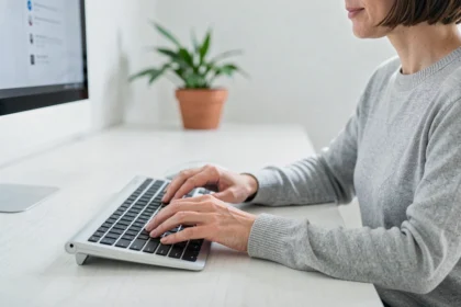 Femme utilisant un clavier ergonomique QWERTY pour soulager ses poignets au bureau